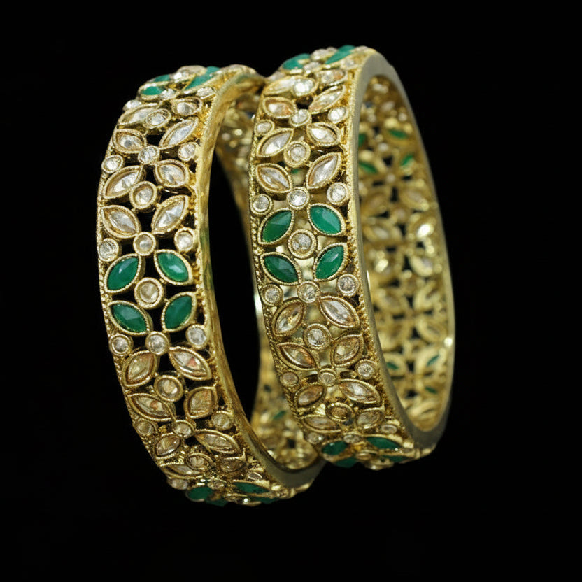 Gold and green jewelry set with 'SAHELI' branding on a gray background