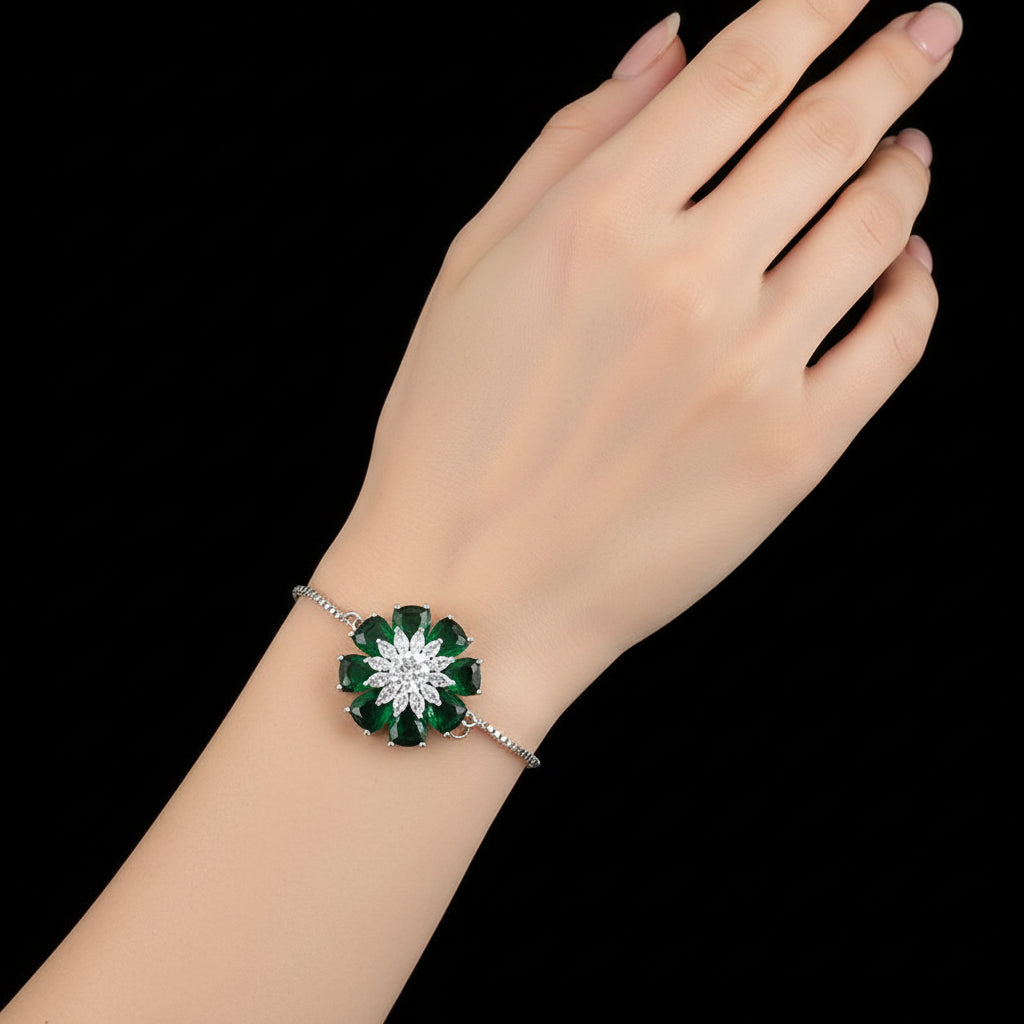 Jewelry with green gemstones and silver chain on a gray background, featuring the brand 'SAHELI'.