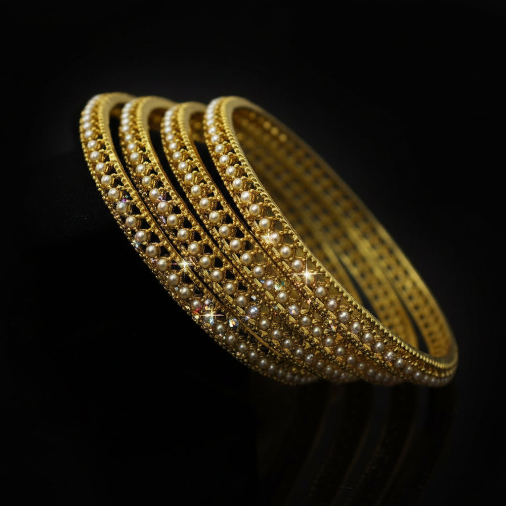 Gold bangles on a black stand with 'Saheli' branding.