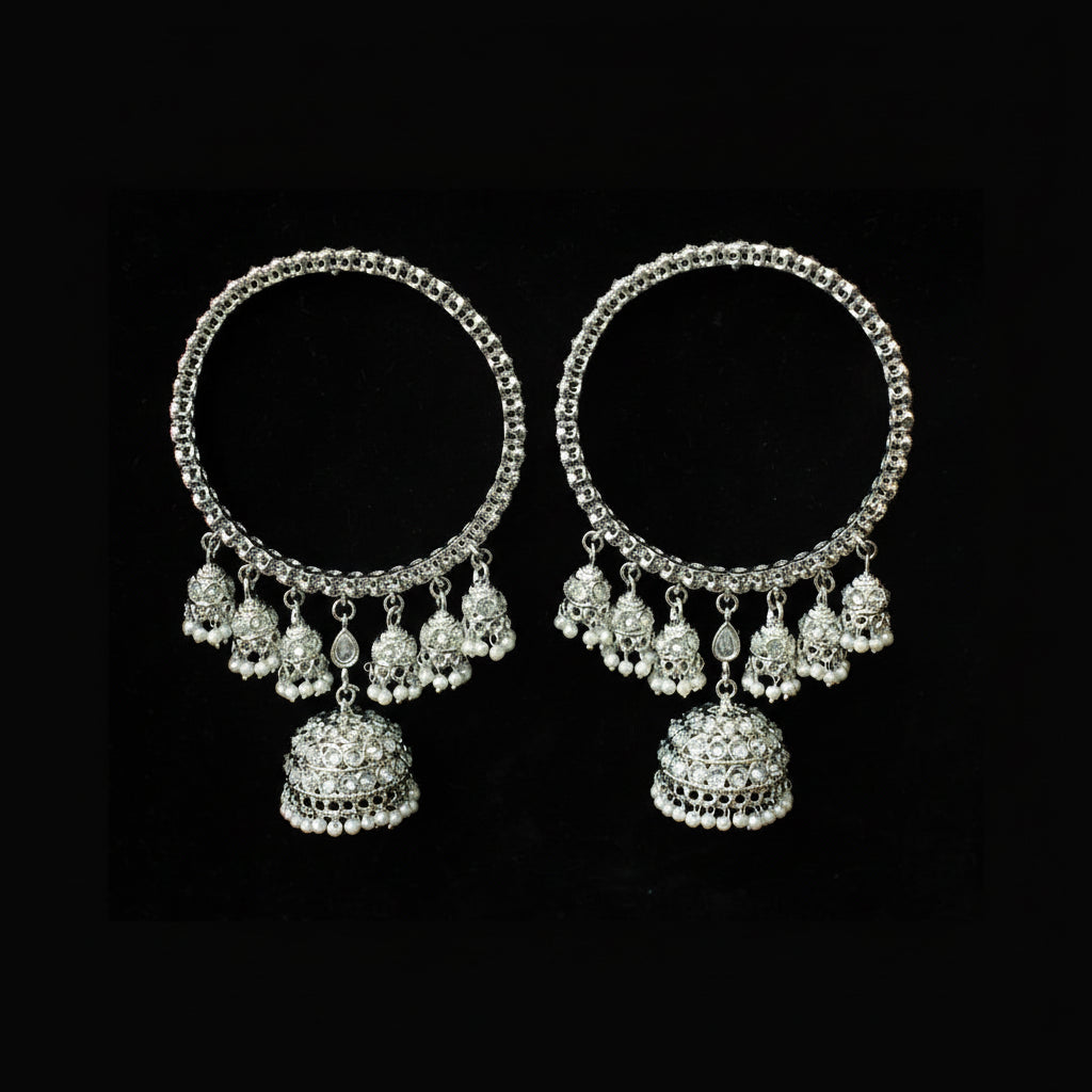 Pair of silver hoop earrings with dangling beads on a black background