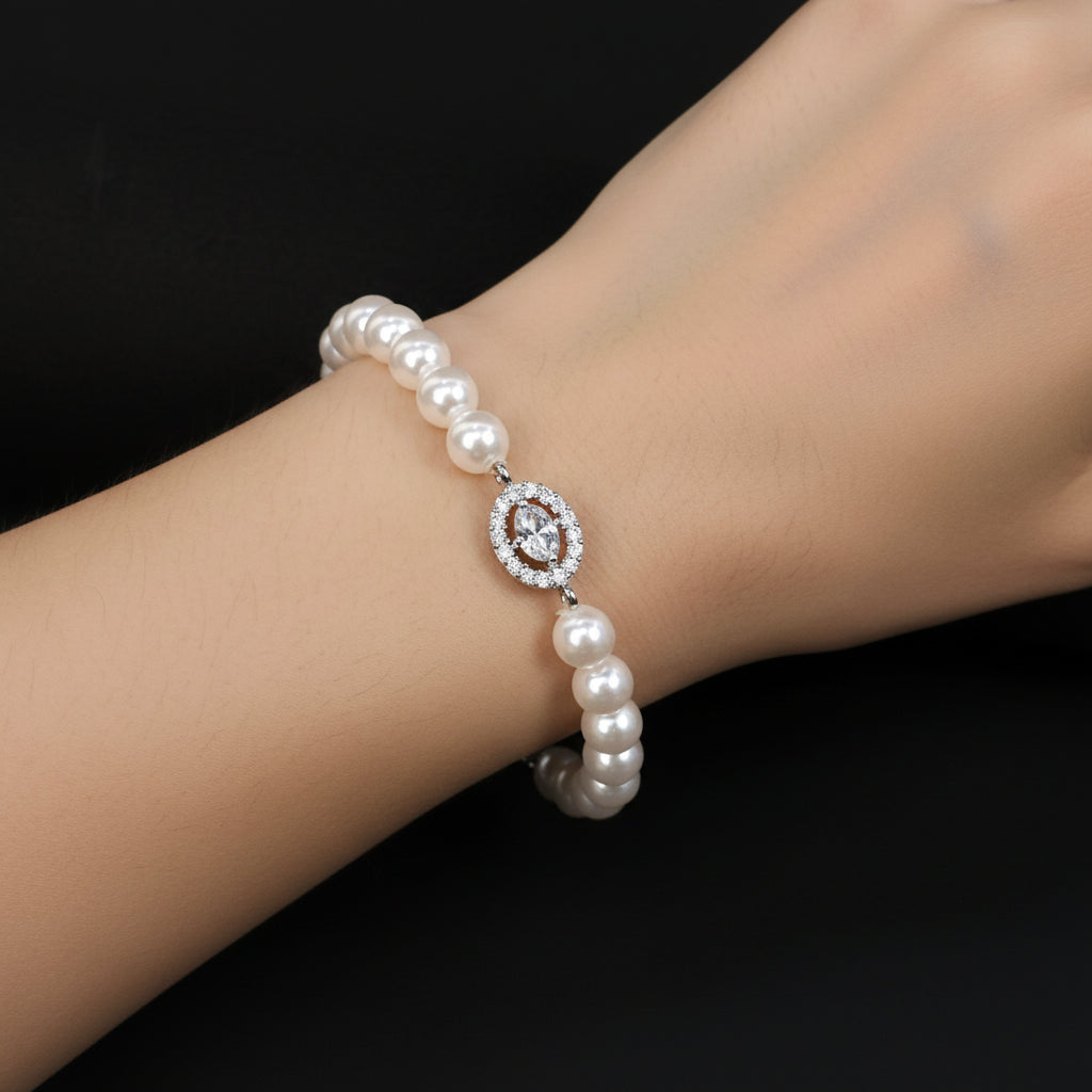 Pearl bracelet with a central gemstone on a black background, featuring the brand 'SAHELI'.