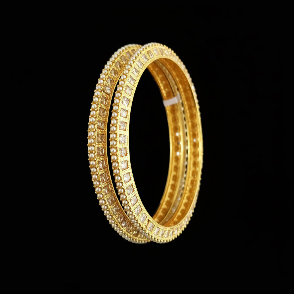 Gold bangles on a black stand with 'SAHELLI' branding.
