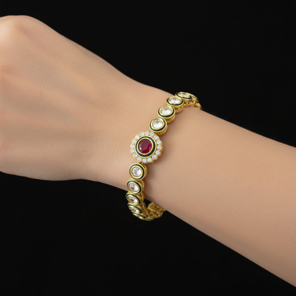 Gold bracelet with red gemstone on a dark background, branded 'SAHELI'.