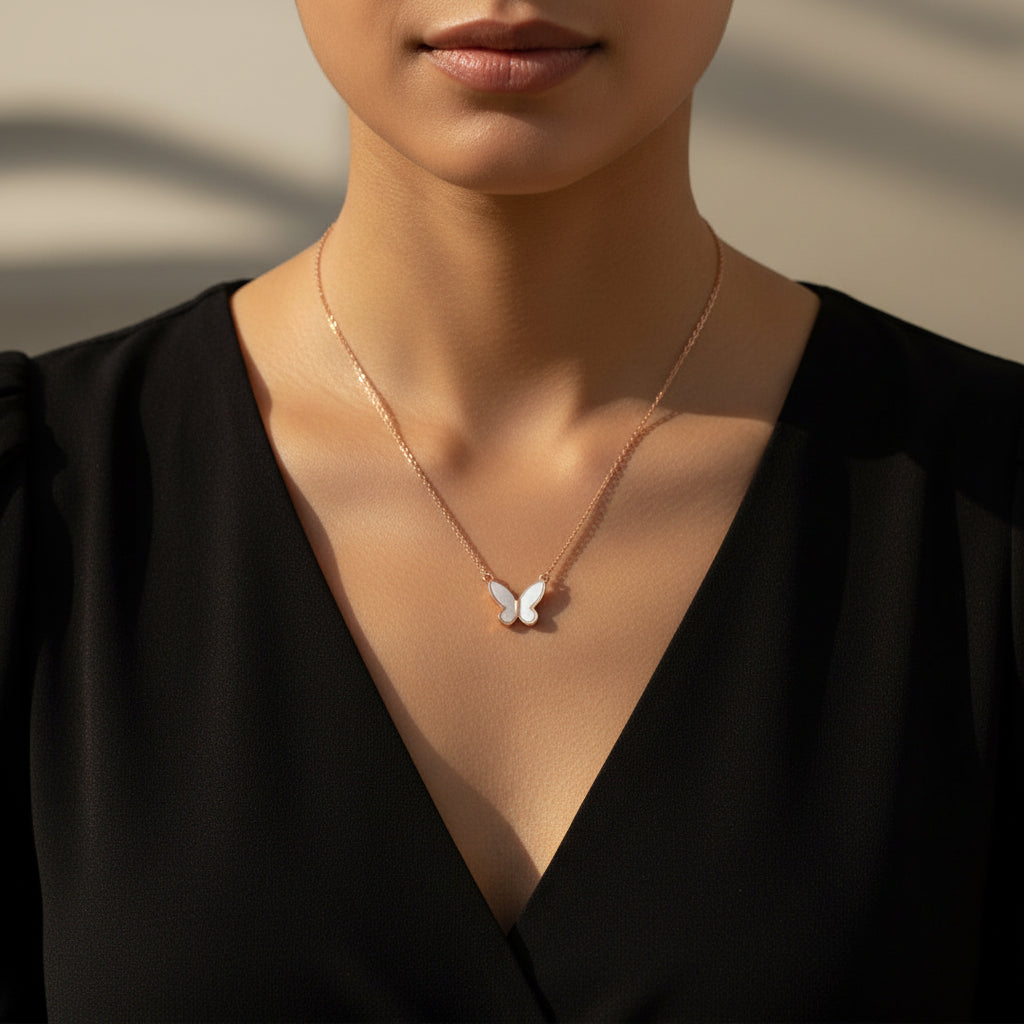 Rose gold butterfly necklace on a branded card against a black background
