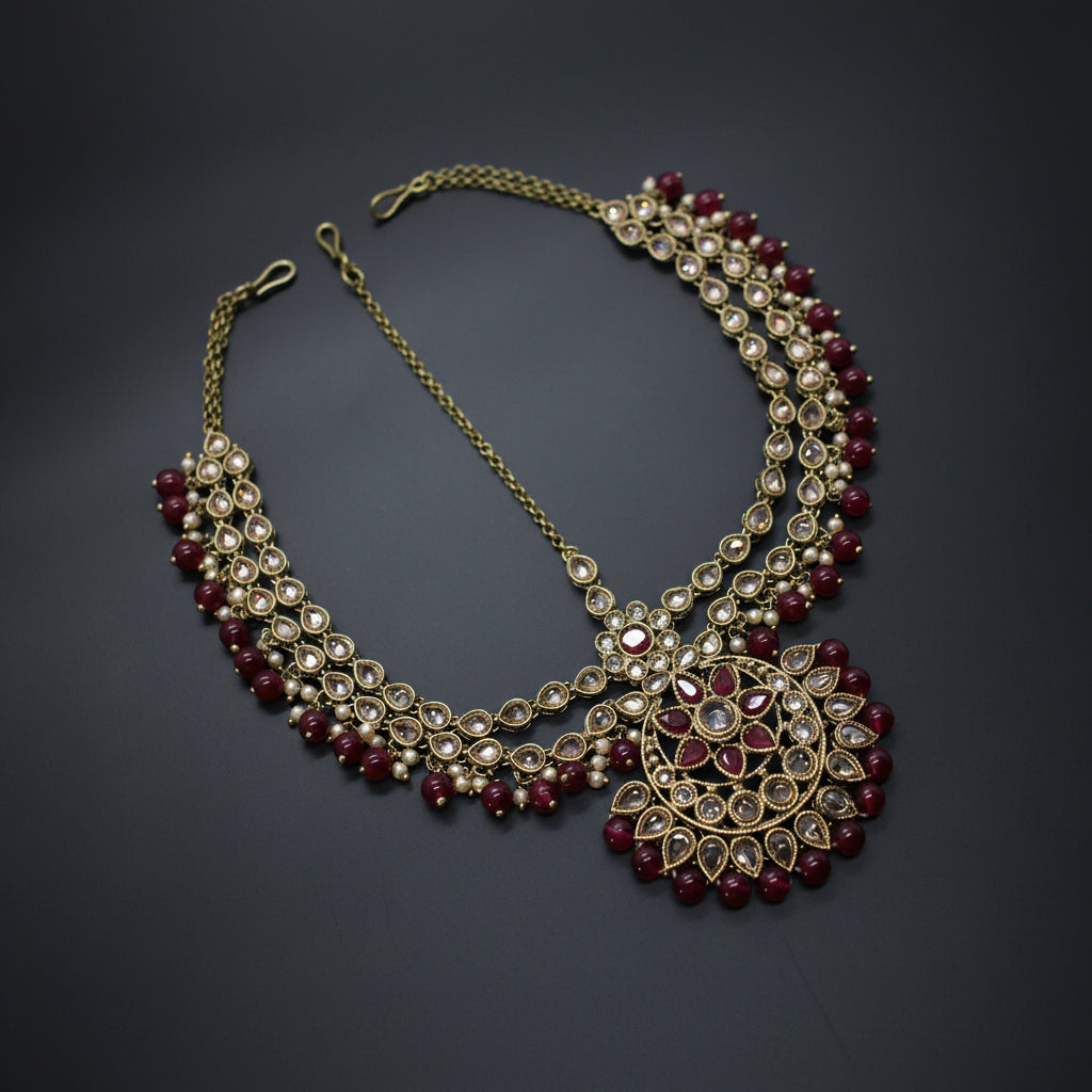 Ornate necklace with red and gold beads on a dark background