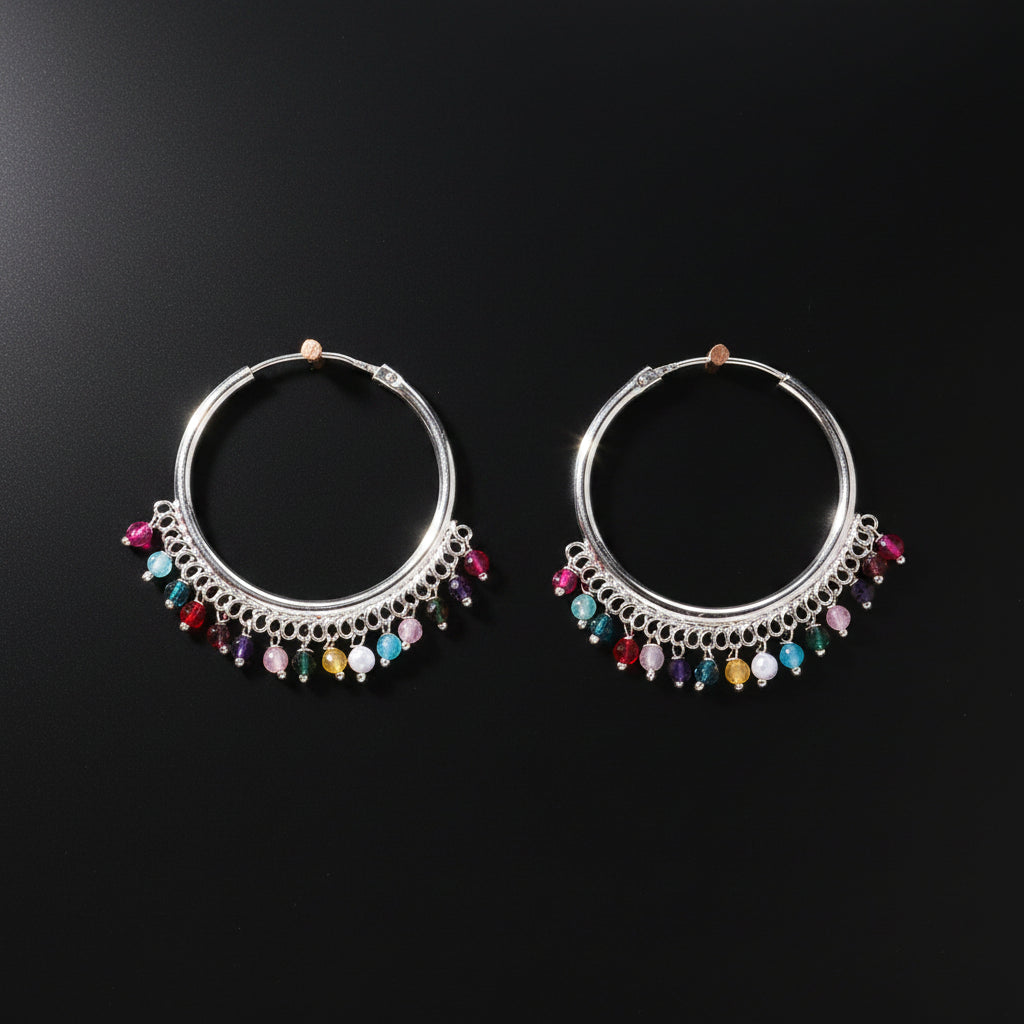Pair of silver hoop earrings with colorful beads on a brown background