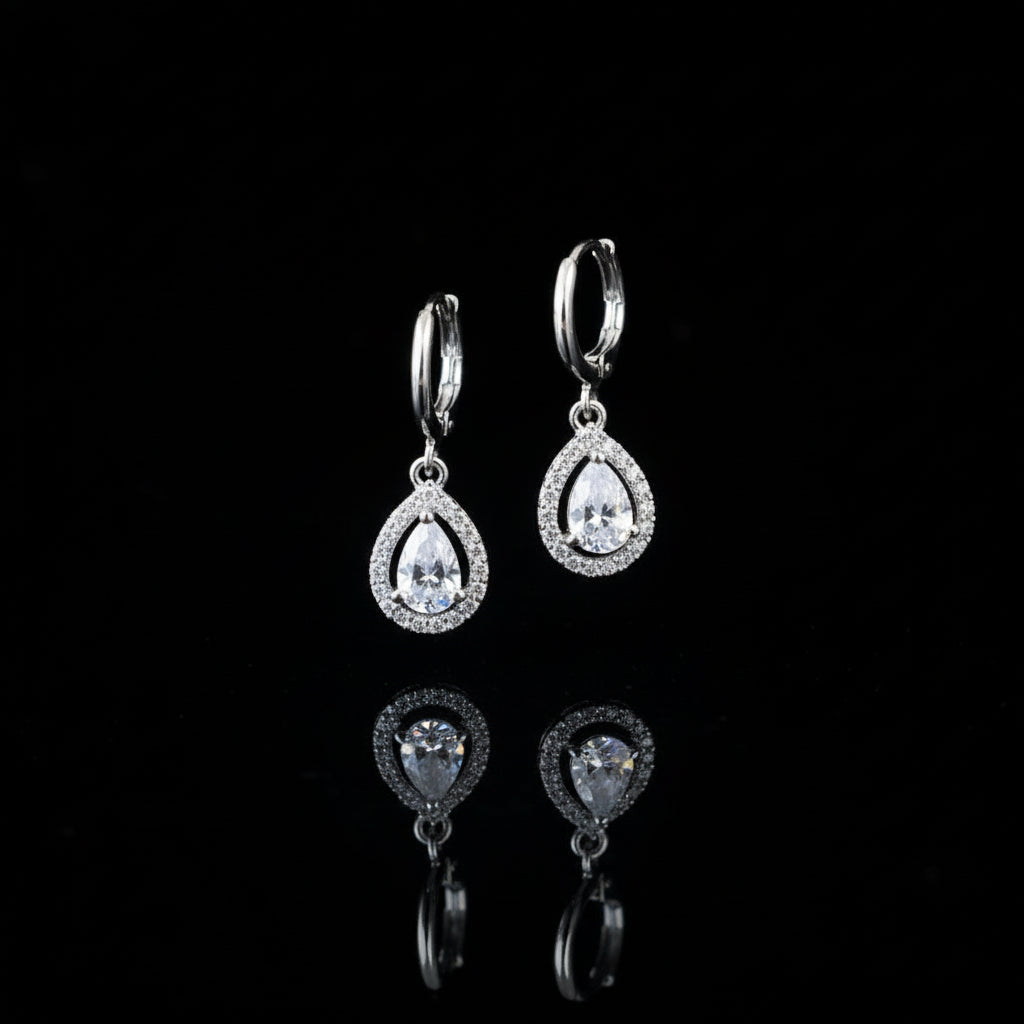 Pair of silver teardrop earrings on a black background