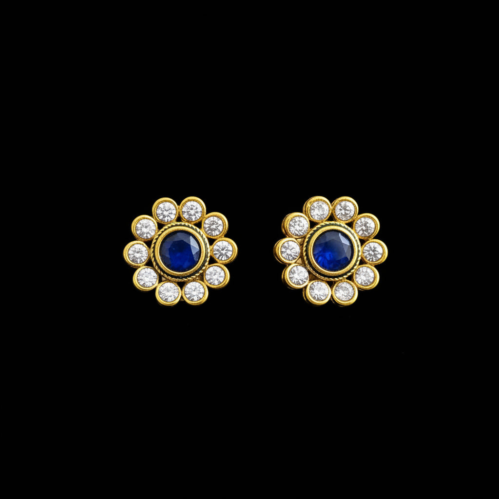 Gold and blue earrings with 'SAHELI' branding on a gray background
