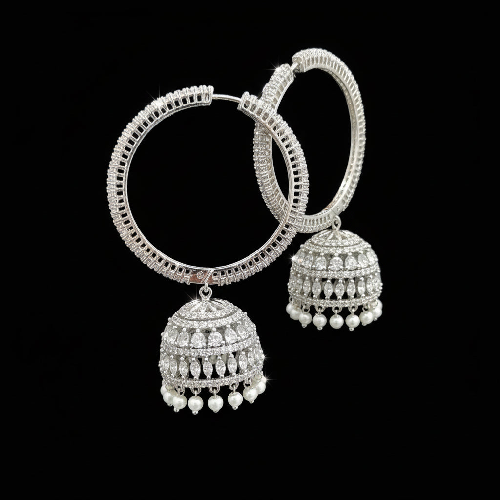 Silver earrings held by a hand with a blurred background