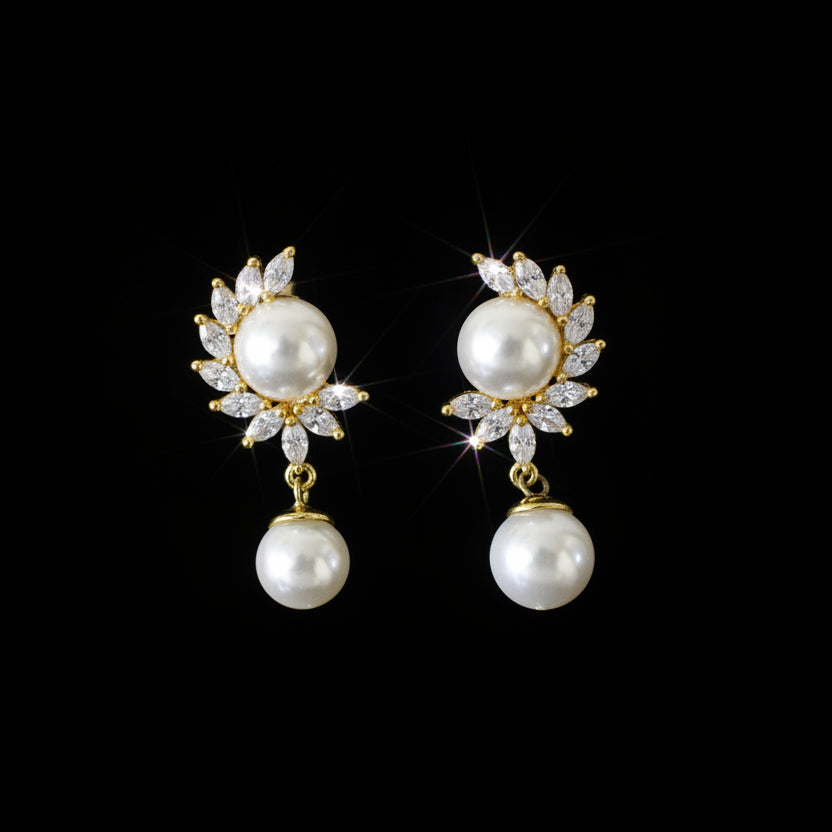 Pearl earrings on a black stand with 'SAHELI' branding on a gray background