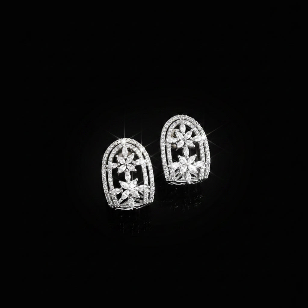Silver earrings with intricate design on a dark background, featuring the brand 'Saheli'.
