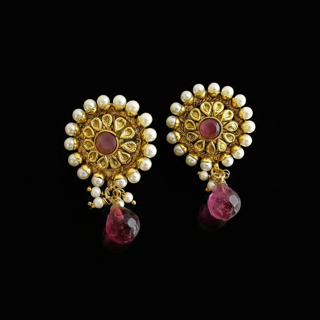 Ornate earrings with gold, pearls, and pink gemstones on a dark background with 'Saheli' branding.