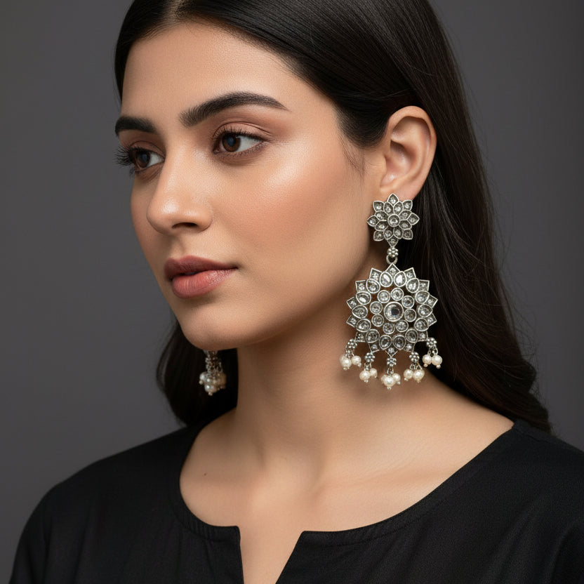 Pair of silver earrings on a black background