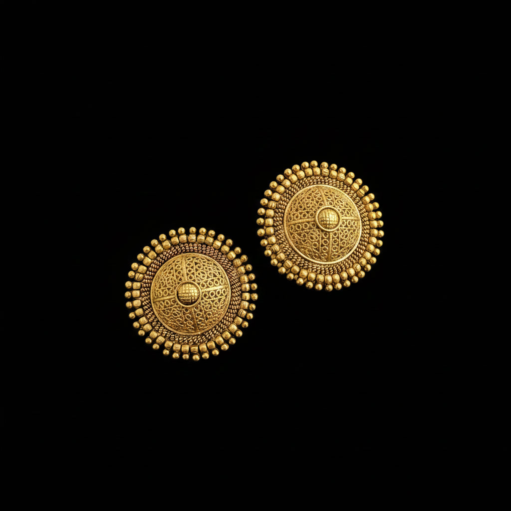Pair of gold earrings on a dark surface