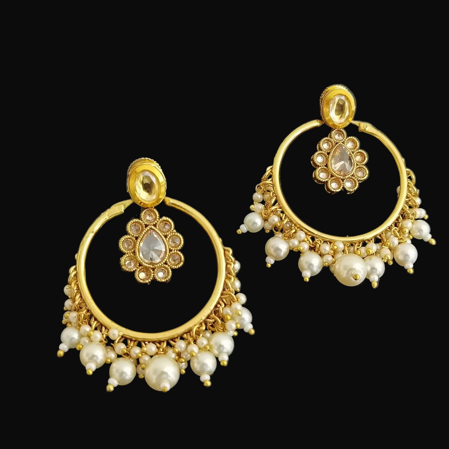 Gold hoop earrings with pearl accents on a black background