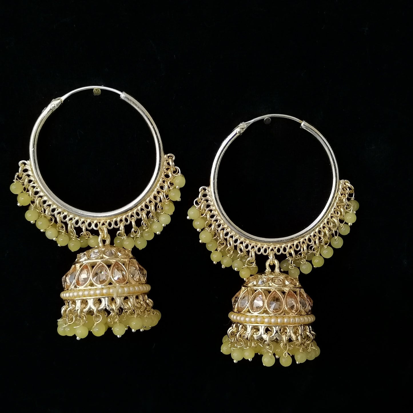 Pair of silver hoop earrings with jhumka designs on a black background