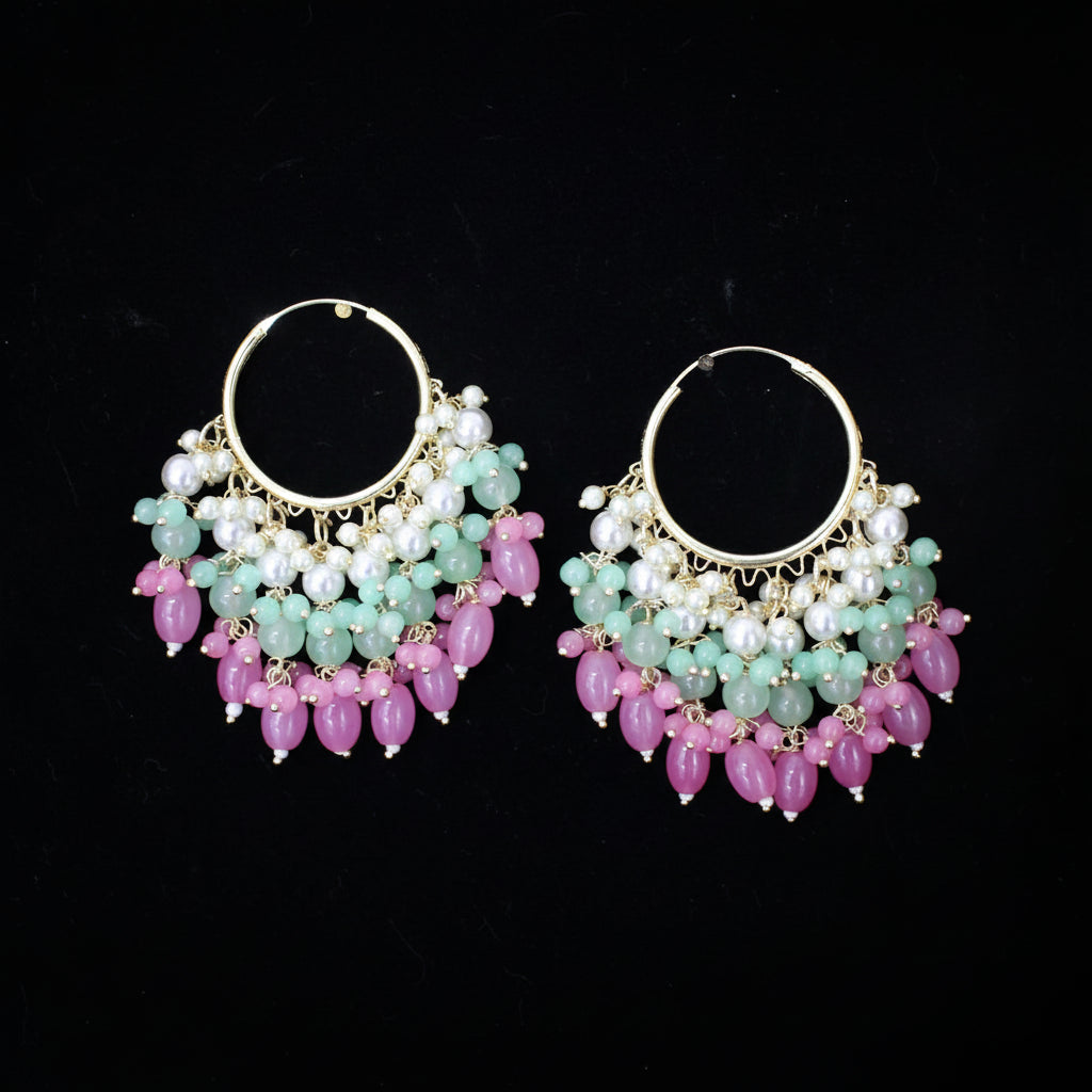 Pair of hoop earrings with pink and green beads on a black background