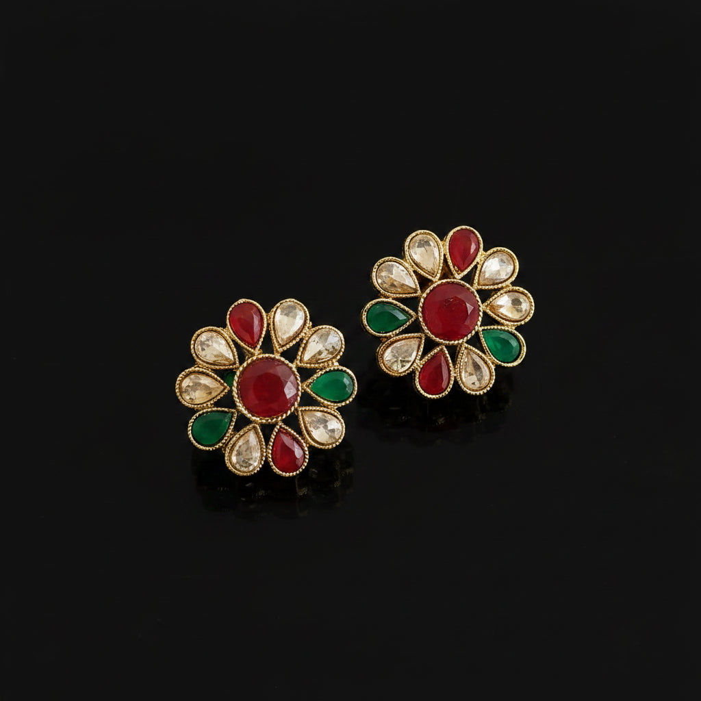 Floral earrings with red and green stones on a gray background, featuring the brand 'Saheli'.