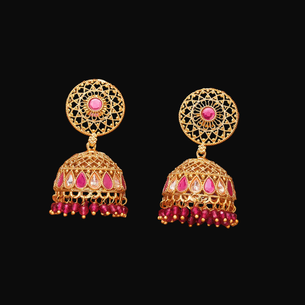 Gold and pink earrings on a brown background