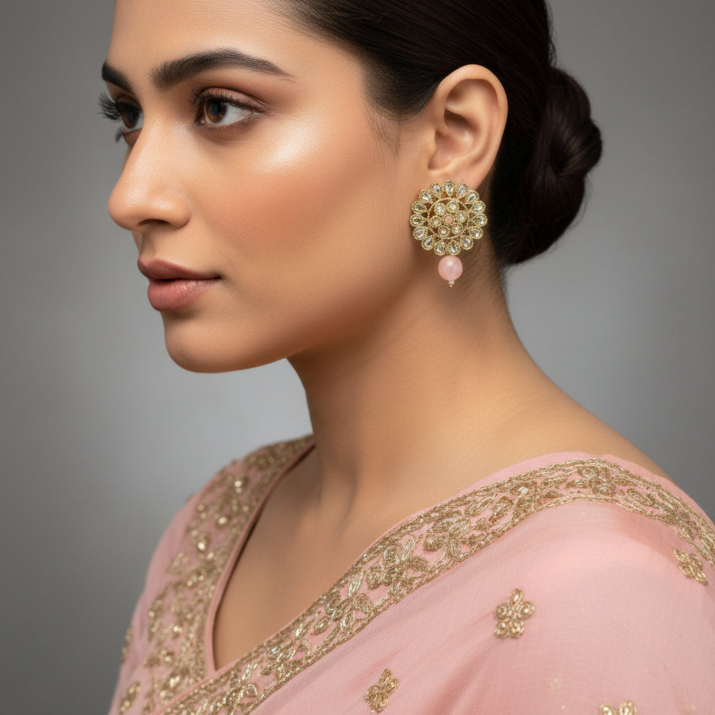 Pair of gold and gemstone earrings on a dark background