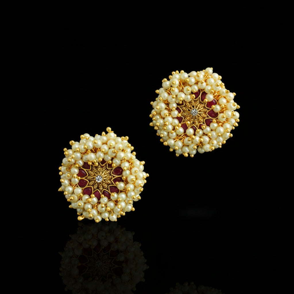 Pair of gold and pearl earrings on a dark background