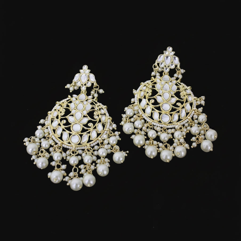 Pair of gold and pearl earrings on a dark background