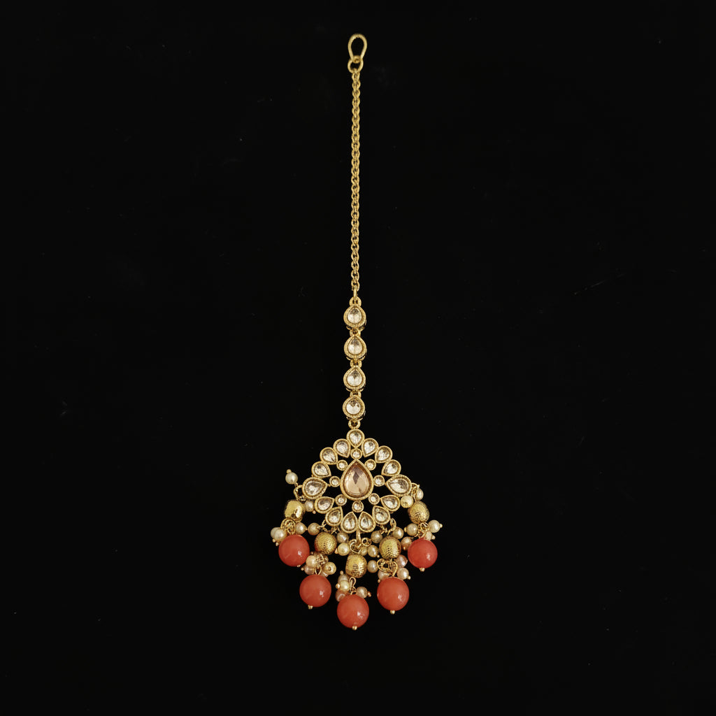 Gold necklace with red beads on a dark background