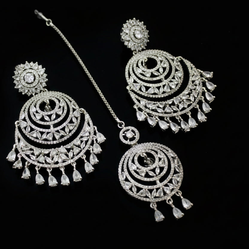 Silver jewelry set with earrings and necklace on a dark background