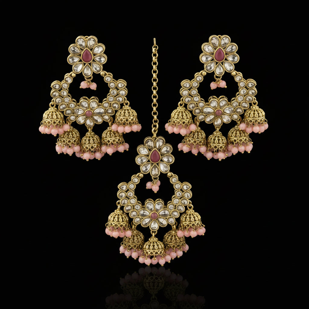 Gold and pink earrings on a black stand with 'Saheli' branding.