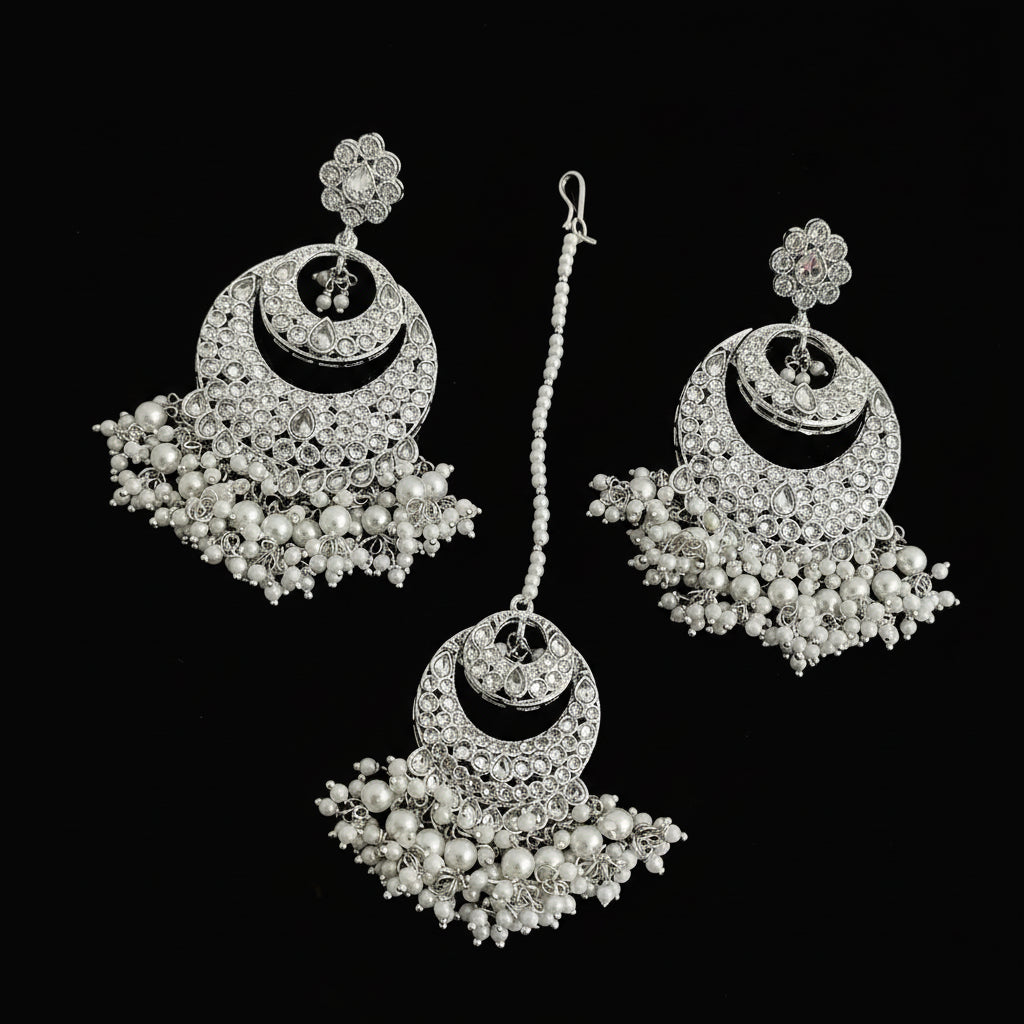 Pair of silver and pearl earrings on a black background