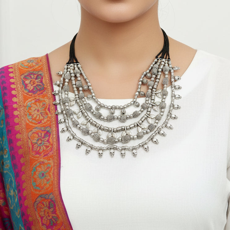 Silver beaded necklace on a dark surface
