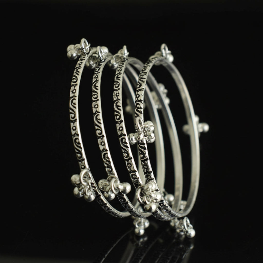 Set of silver hoop earrings on a black stand against a gray background
