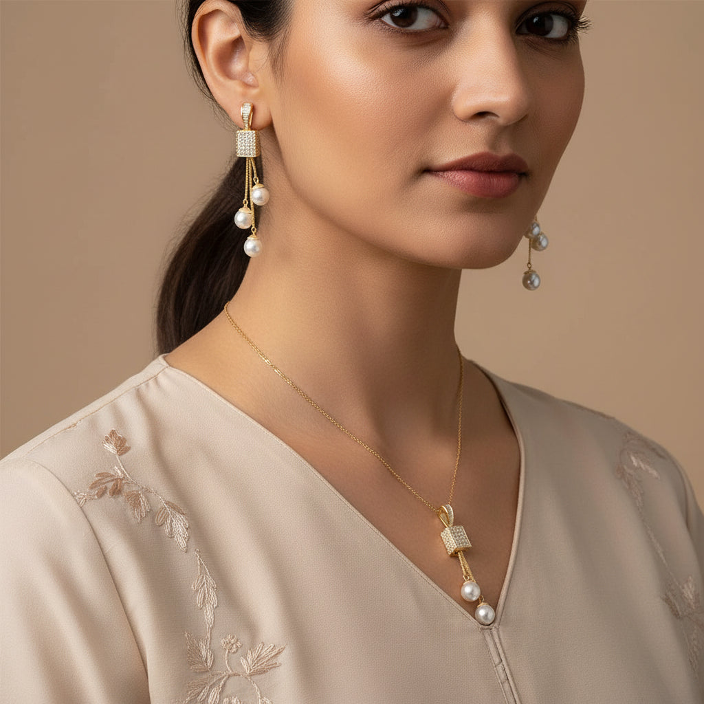 Pair of gold earrings with pearl drops on a black background