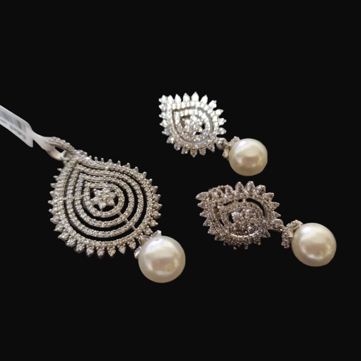 Silver earrings with pearls on a laptop keyboard