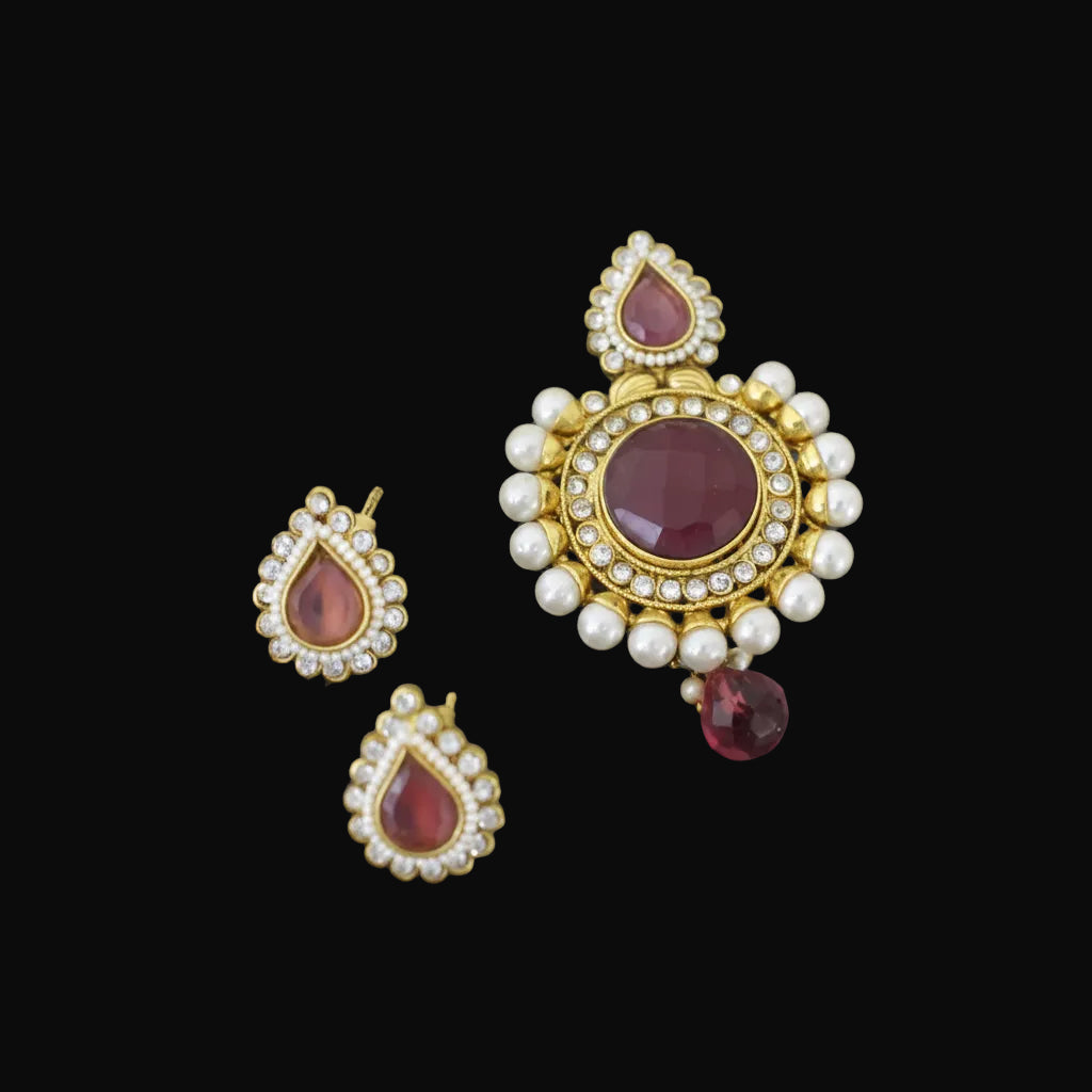 Jewelry set with gold, red, and pearl elements on a dark background, featuring the brand 'SAHELI'.