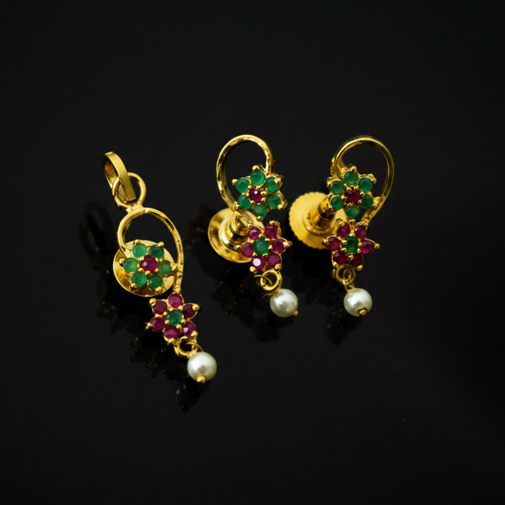 Gold earrings with gemstones and pearls on a gray background, branded 'SAHELI'.
