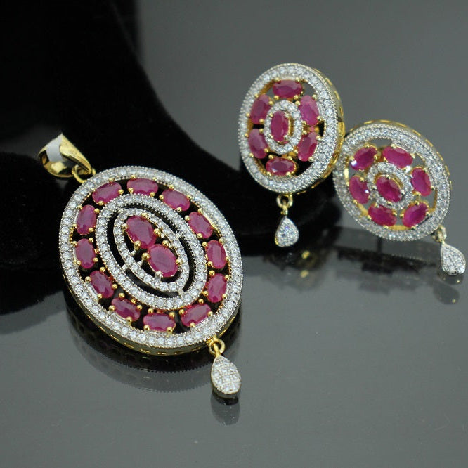 Jewelry set with circular pendants featuring red stones and gold accents on a dark background, branded 'Saheli'.