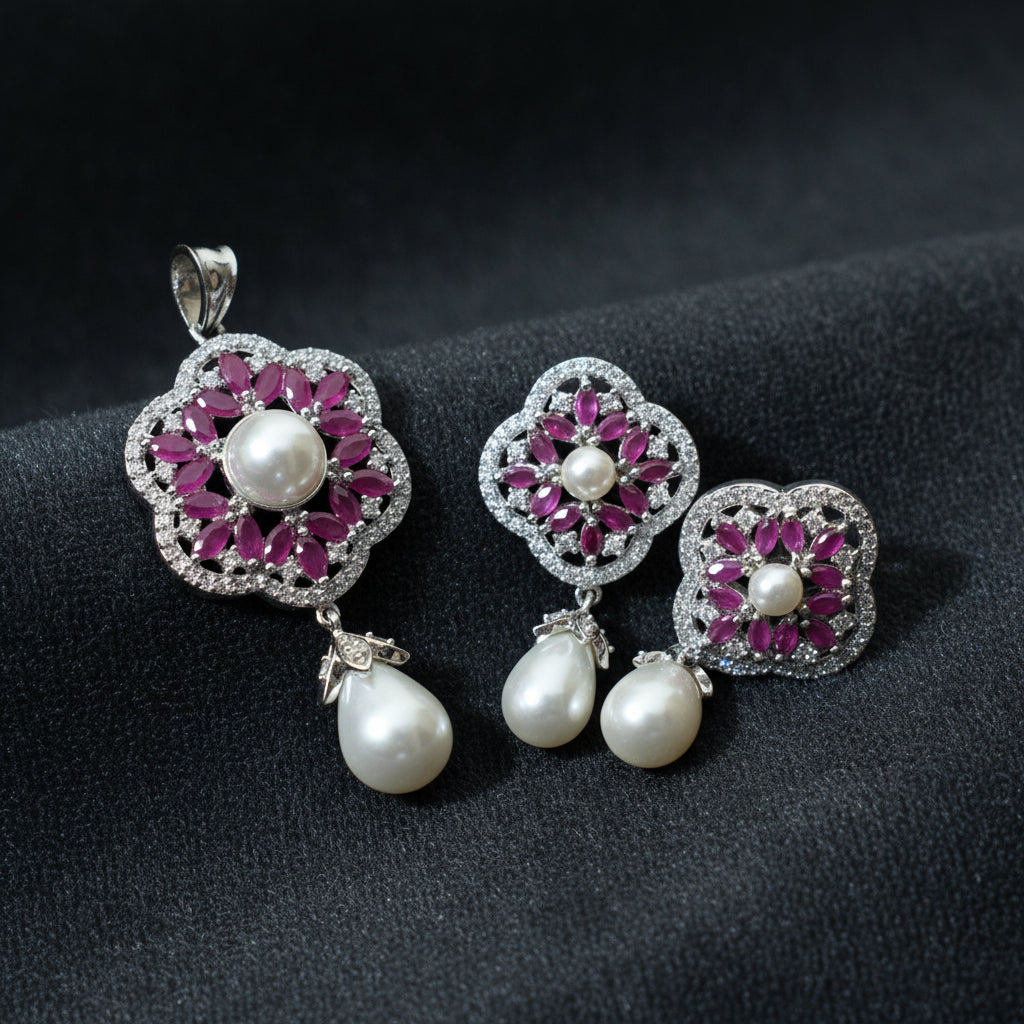 Jewelry set with pink gemstones and pearl drops on a dark background, featuring the brand 'Saheli'.
