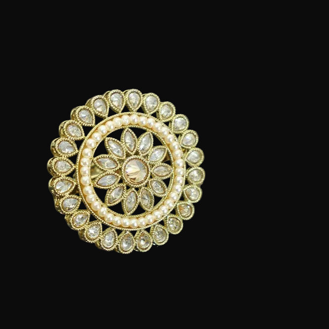 Gold and diamond brooch with 'SAHELI' branding on a gray background