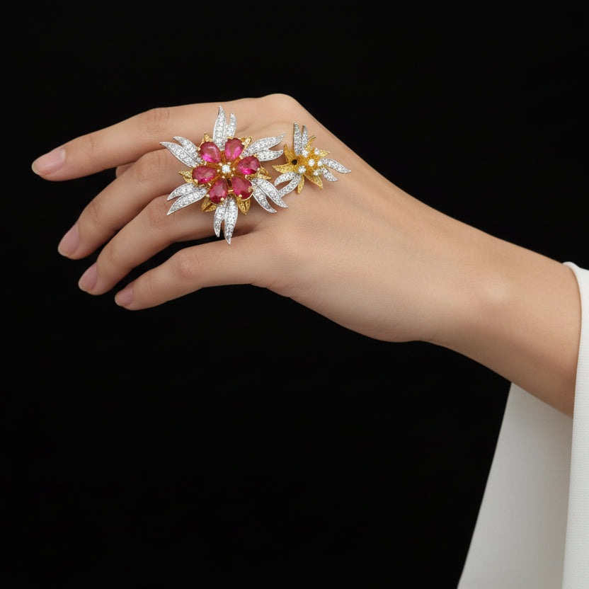 Jewelry set with red gemstones and gold accents on a gray background, featuring the brand 'SAHELI'.