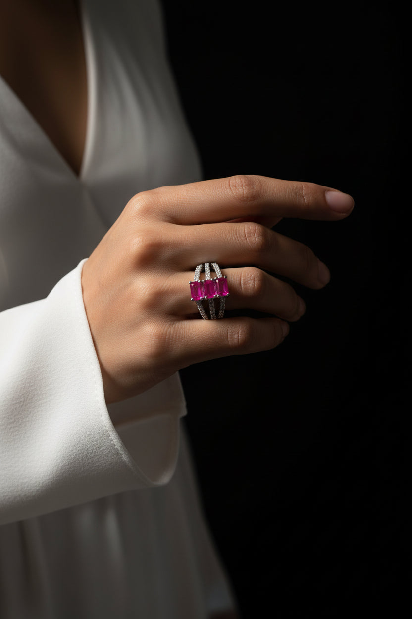Silver ring with a pink gemstone on a dark background, featuring the brand 'SAHELI'.