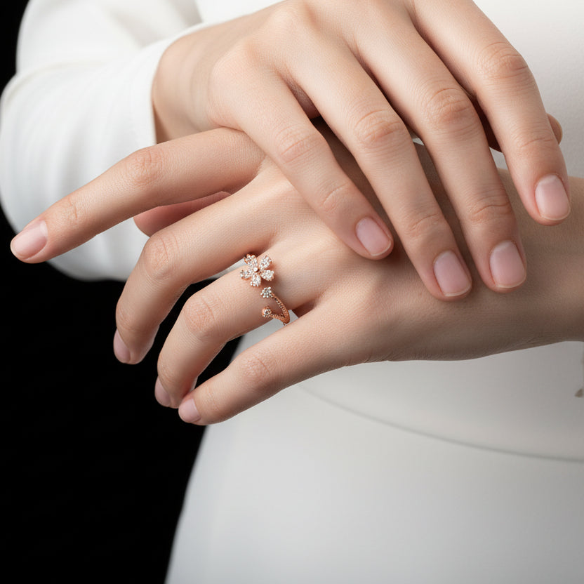 Gold ring with a floral design on a black mannequin hand against a gray background