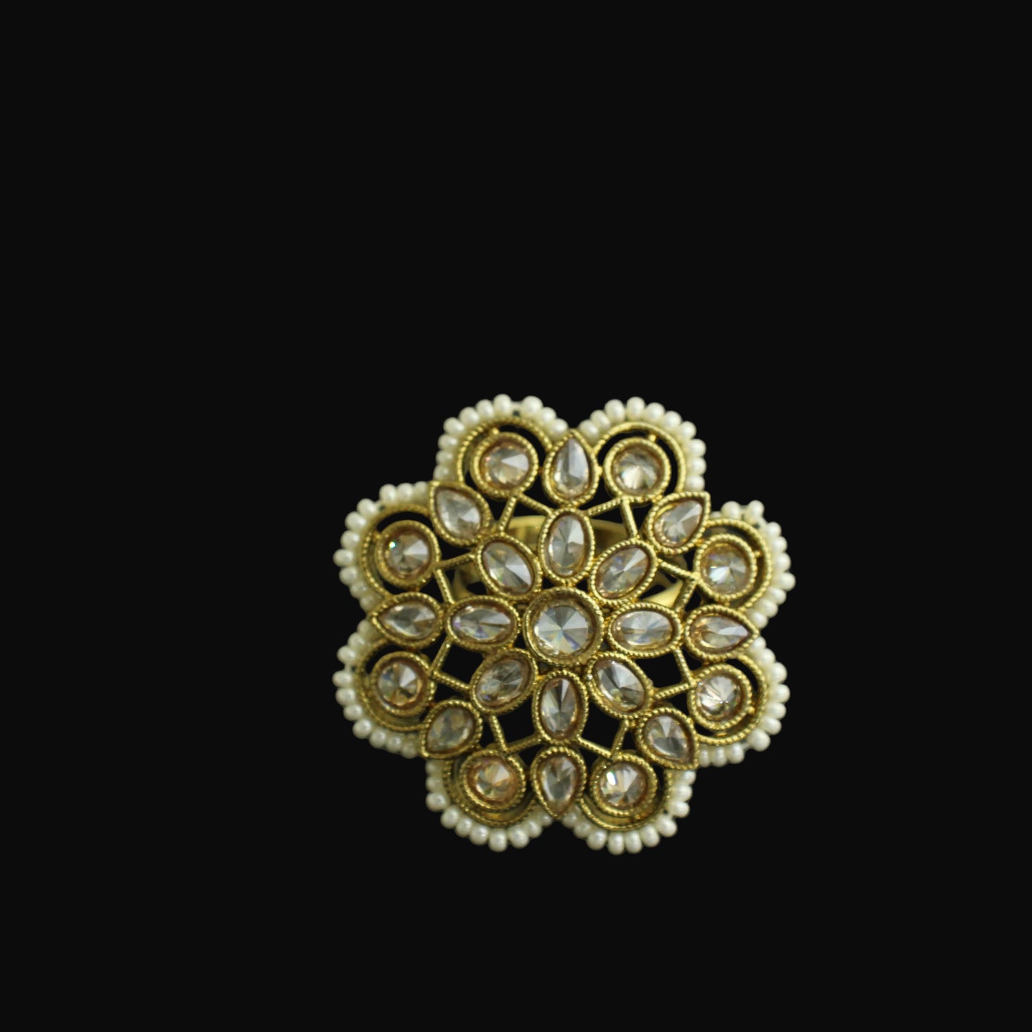Gold ring with intricate design on a black background