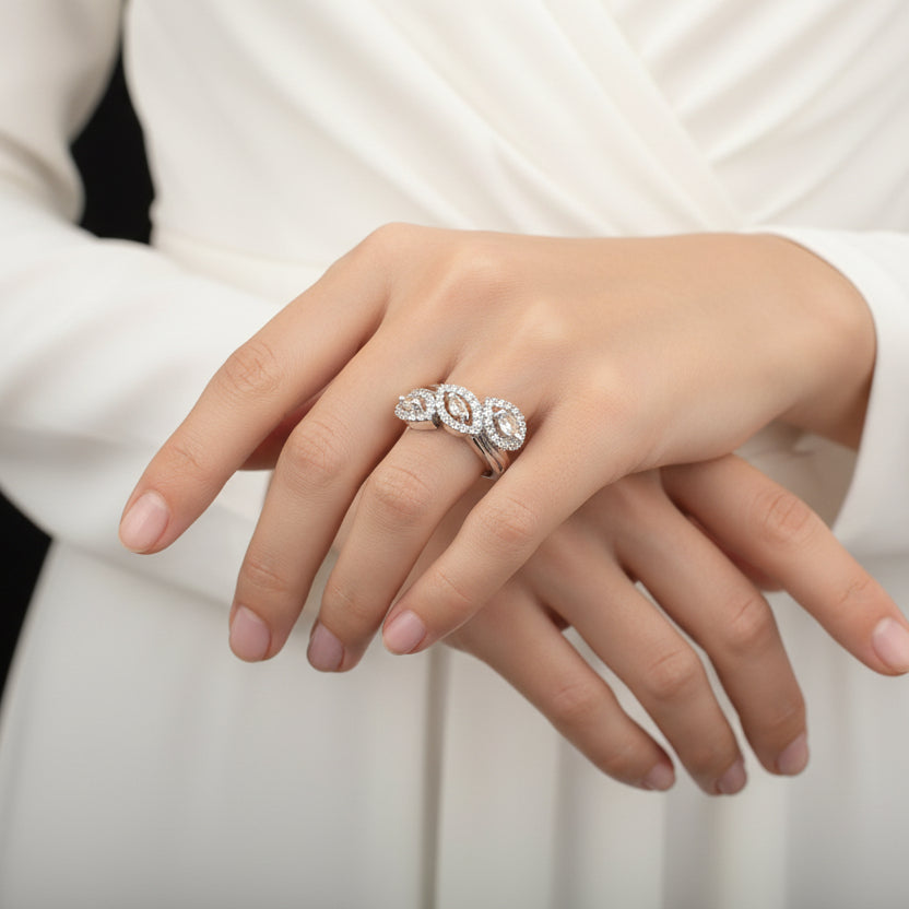 Silver ring with diamonds on a gray background, branded 'SAHELI'.