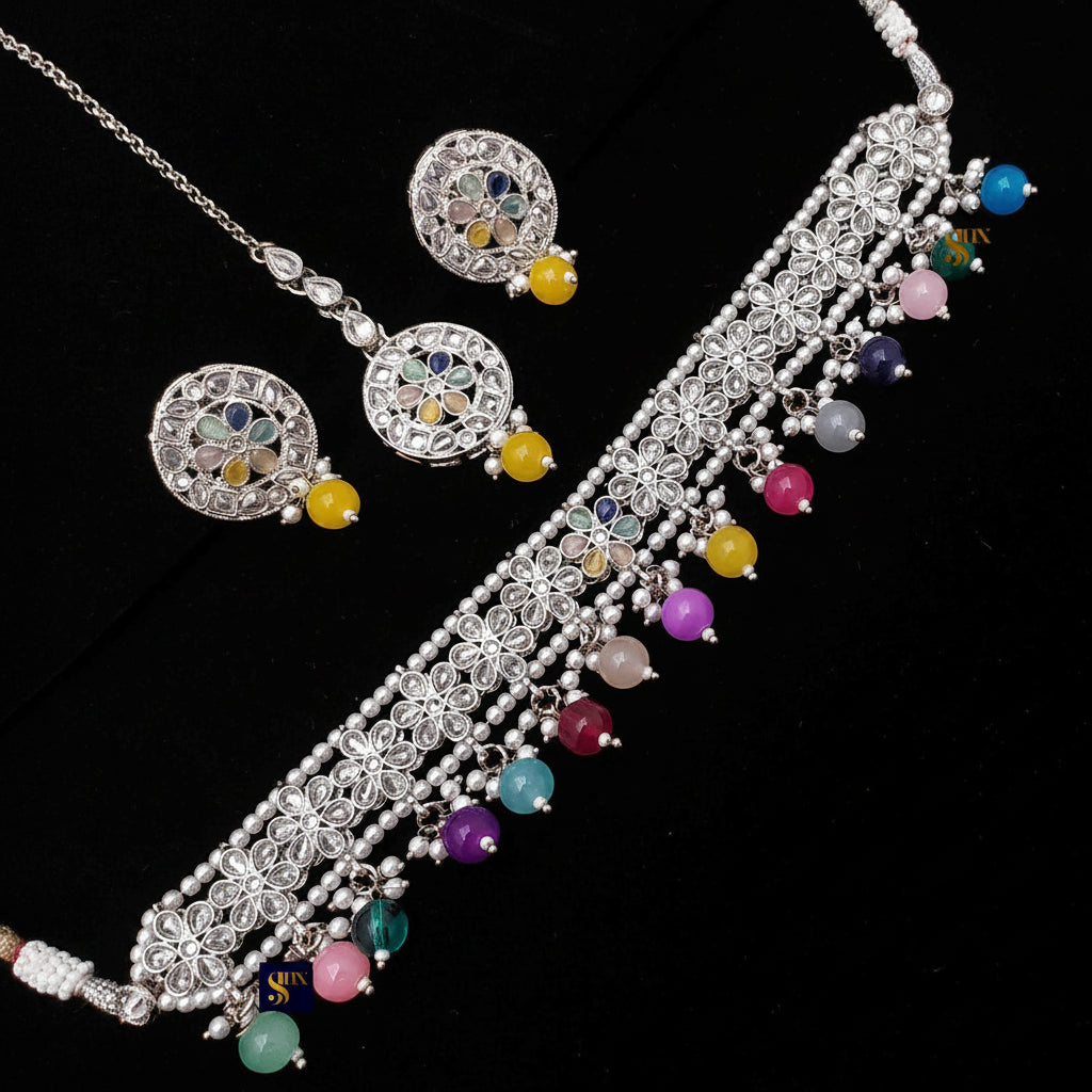 Silver necklace with colorful beads and matching earrings on a black background