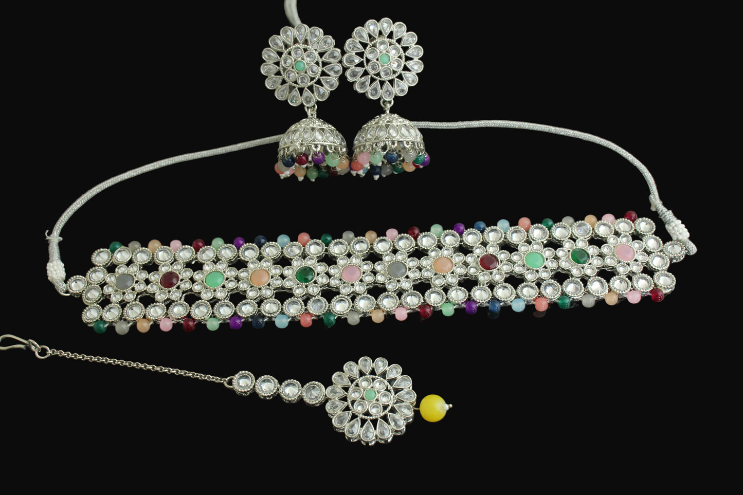 Jewelry set with necklace, earrings, and decorative item on a dark surface