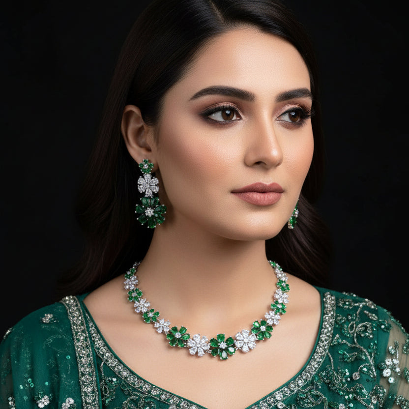 Jewelry set with necklace and earrings featuring green and white stones on a black background, branded 'Saheli'.