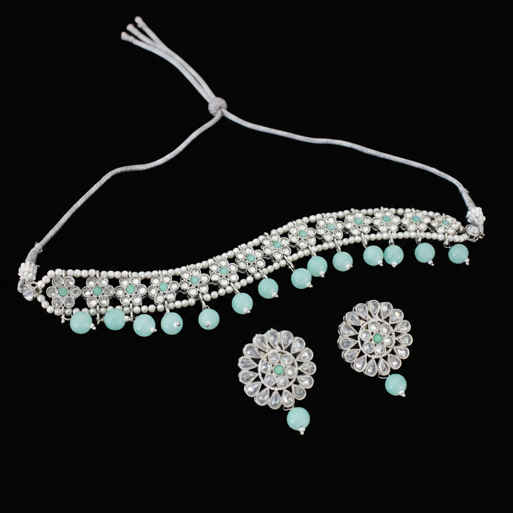 Jewelry set with necklace, earrings, and 'Saheli' brand logo on a dark background