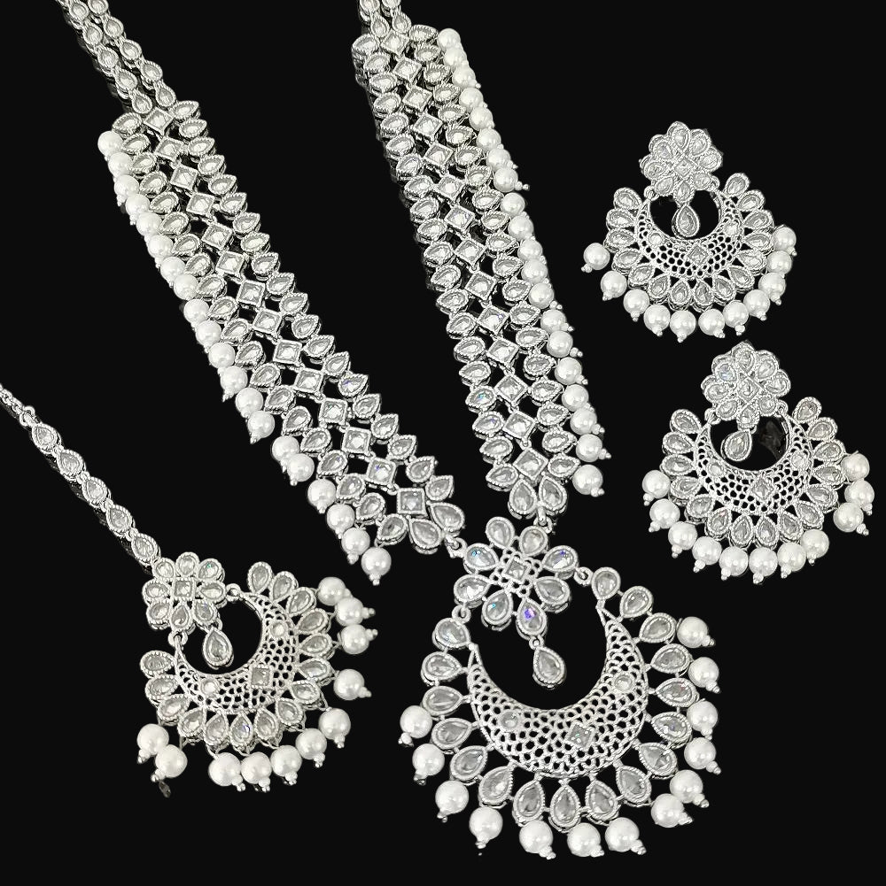 Silver jewelry set with necklace and earrings on a dark background, featuring the brand 'Saheli'.