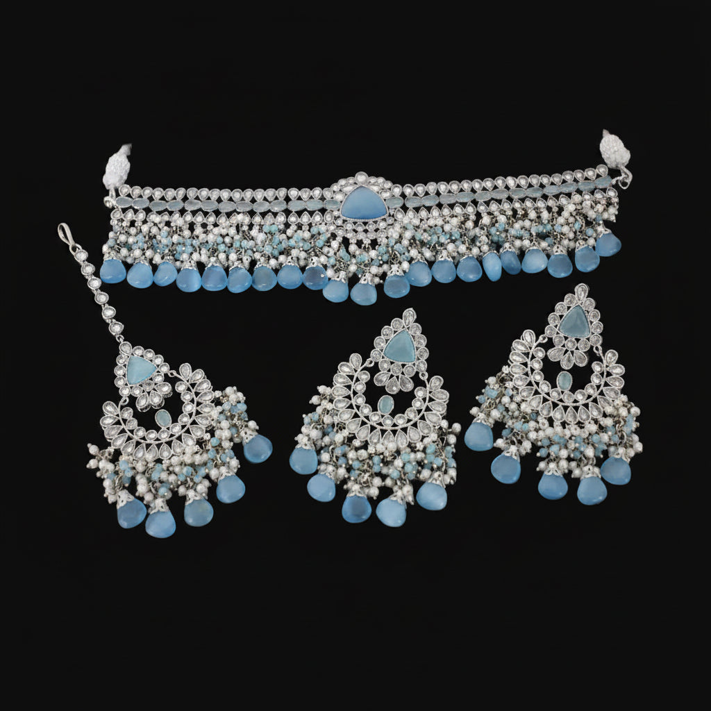 Jewelry set with necklace and earrings featuring blue stones on a dark background